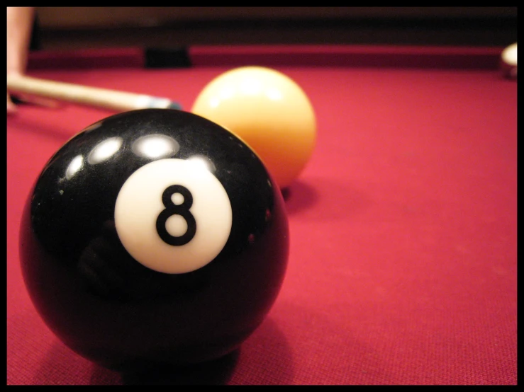 a pool table with eight ball and pool cues