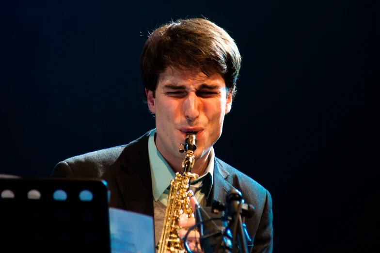 a young man plays the saxophone at a concert