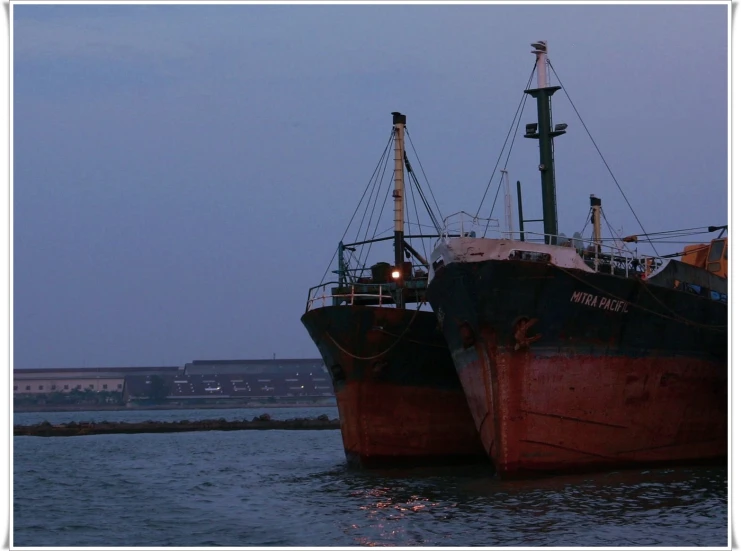 two ships are docked with the fog coming in