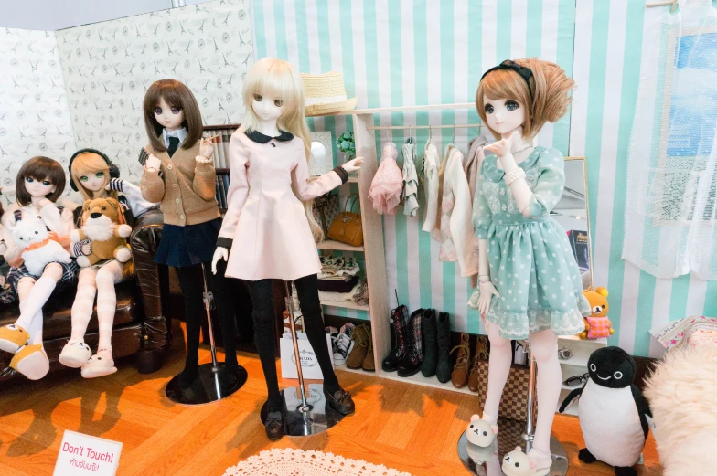 several dolls sit in a room full of clothing and toys
