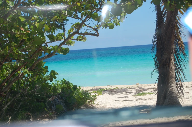 the view of a beautiful beach and ocean from across the road