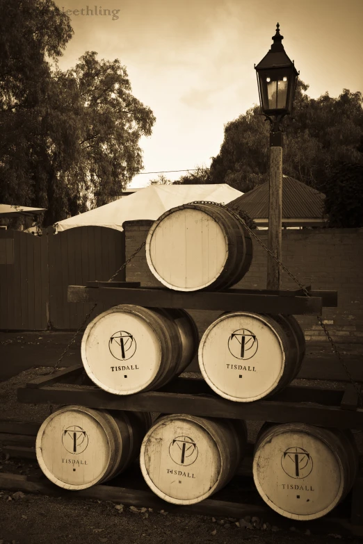 stacked wine barrels sit in front of an outdoor lamppost