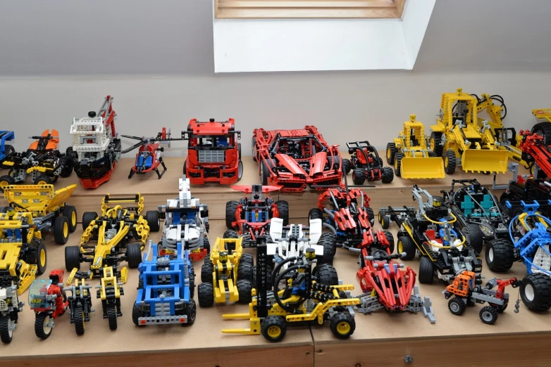 a display with many lego toy vehicles on top of wooden shelves
