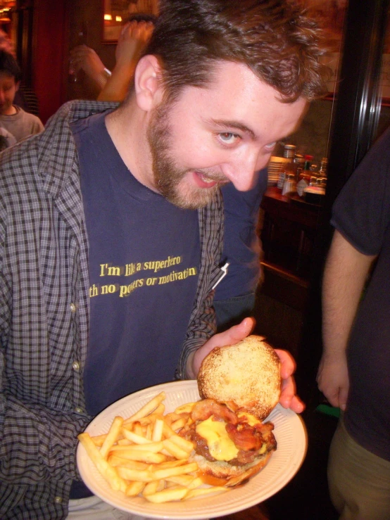 a man that is holding a burger and french fries