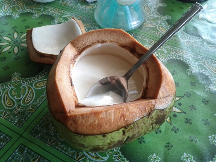 a wooden bowl filled with coconuts and a spoon