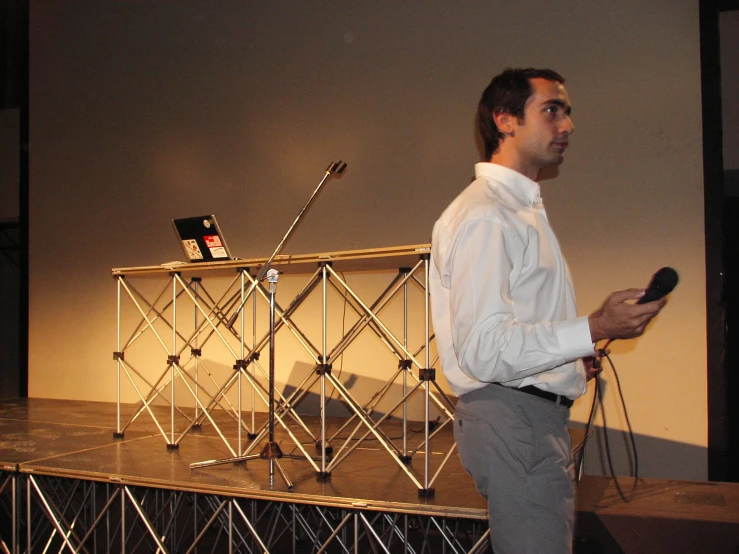 a man standing on stage with microphone and radio next to him