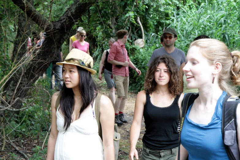 a group of people walking on a path with trees in the background