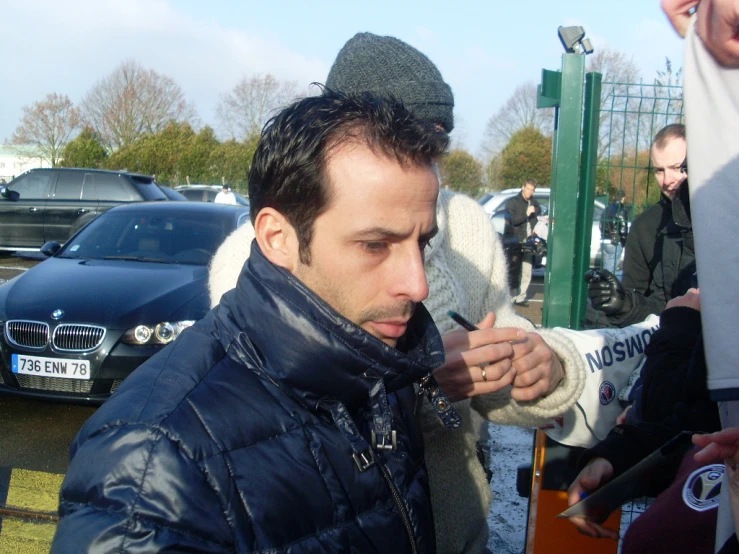 a man wearing a jacket smoking soing in his hands