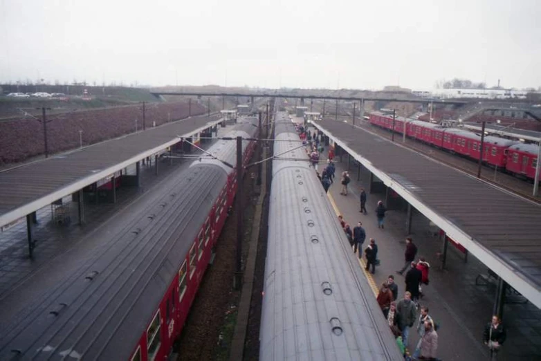 there are many people walking around the train yard