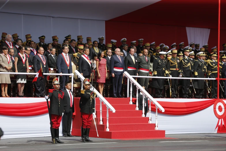 a group of people in uniform standing on a red carpeted stage