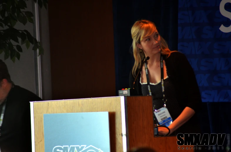 woman at a podium delivering a speech in front of an audience