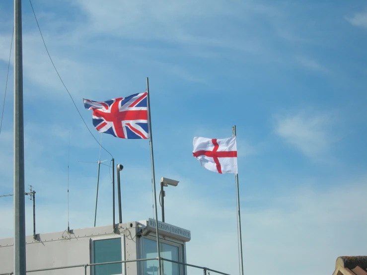 a group of flags on a flag pole waving in the wind