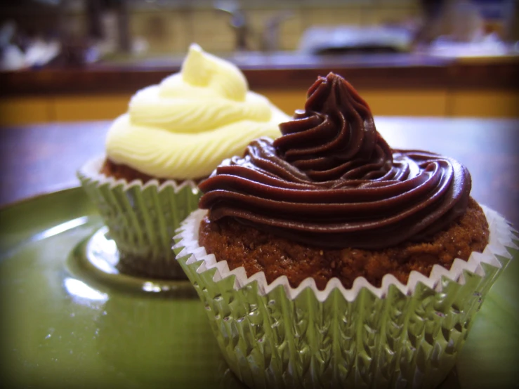 two chocolate cupcakes with cream on them