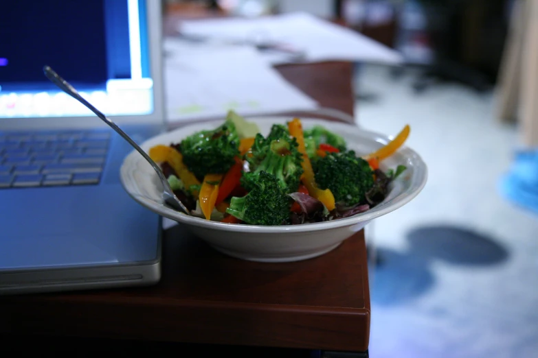 a salad in front of a laptop