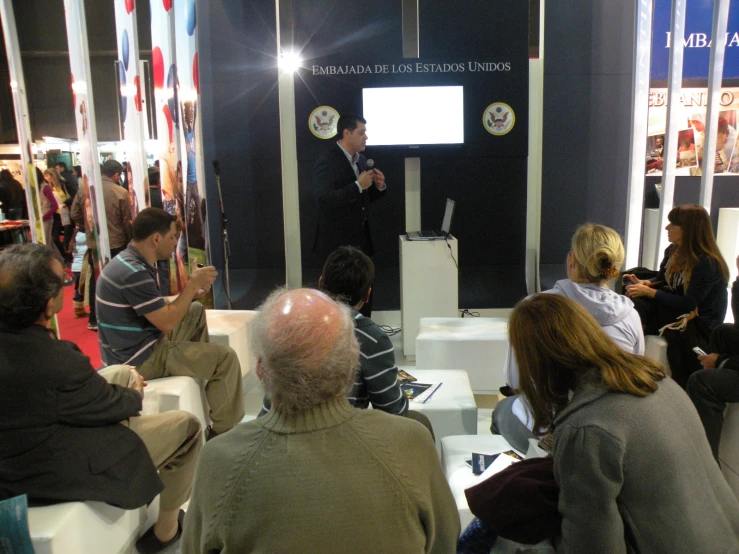 group of people watching a man giving a speech