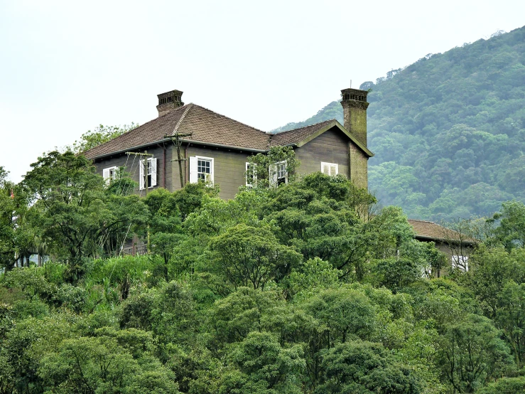 a large brown house on top of a green hill