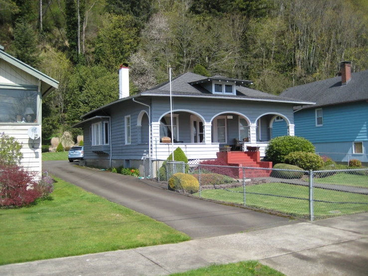 a house with blue paint next to a grassy yard