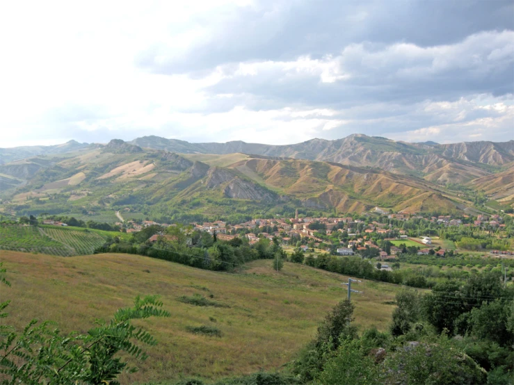 the landscape has a lot of hills and buildings in the background