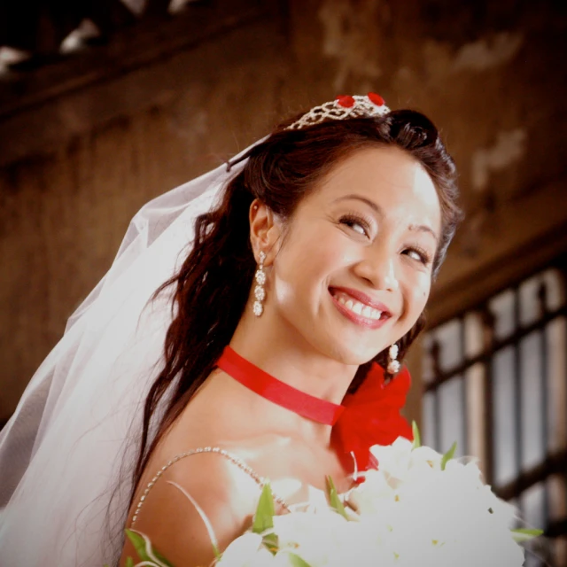 woman in wedding outfit holding flowers smiling