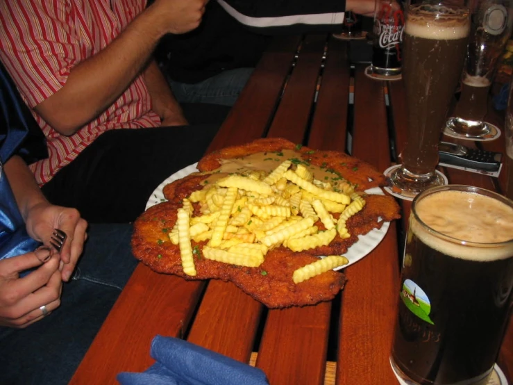 pizza is displayed on a wooden table next to two drinks