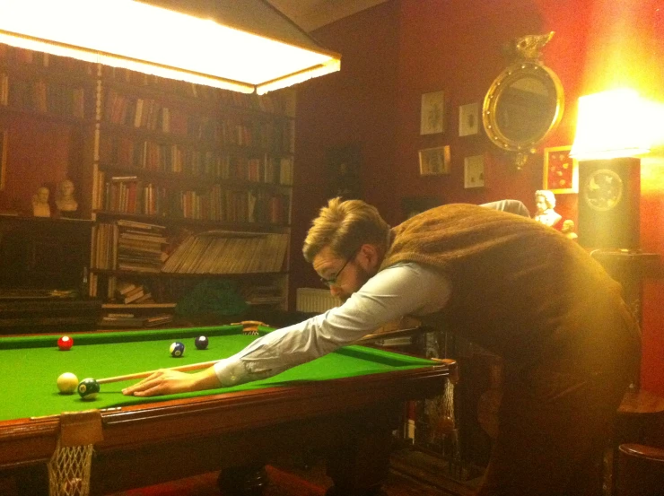 a man in a tie is playing pool