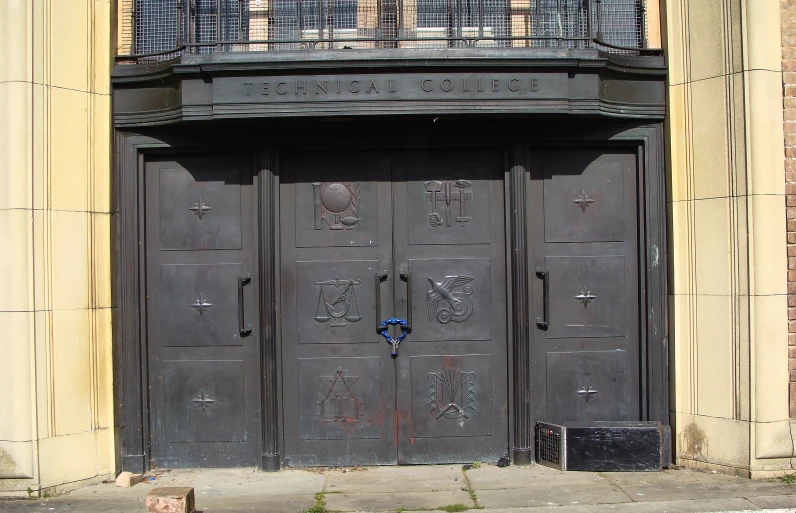 two wooden doors and railings on an old building