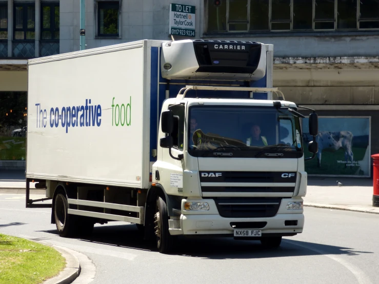 a large truck traveling down the street in front of buildings