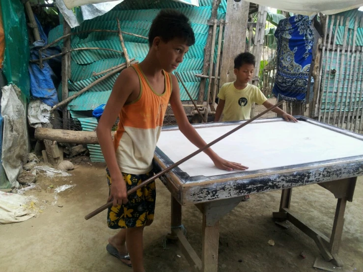 two boys playing a game with their homemade board