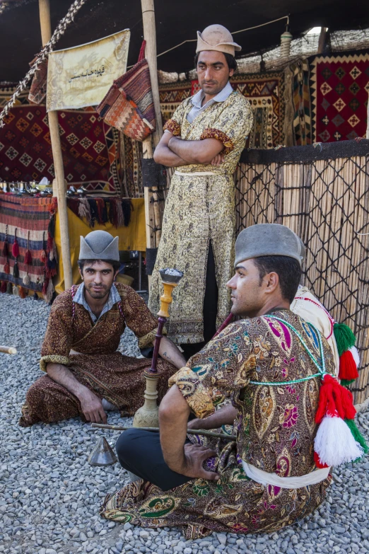 a group of people sitting next to each other in front of some cloth