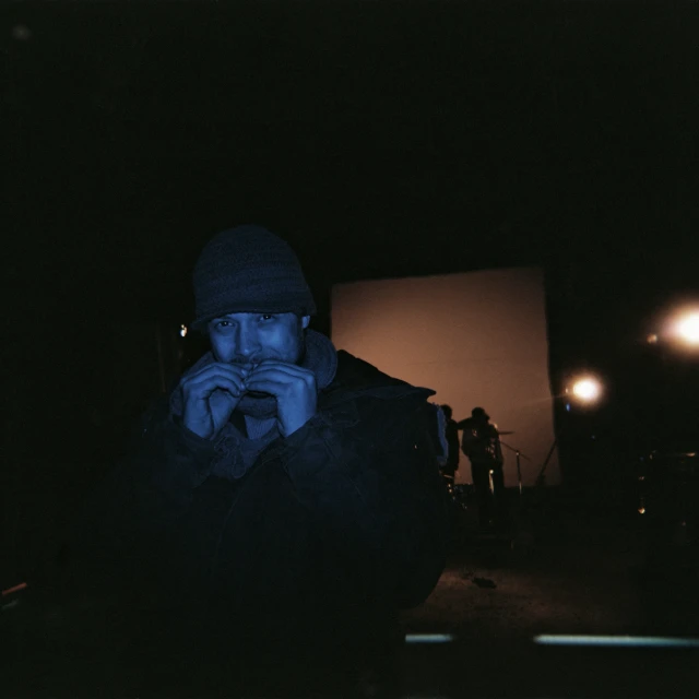 a man standing next to a large screen holding a camera