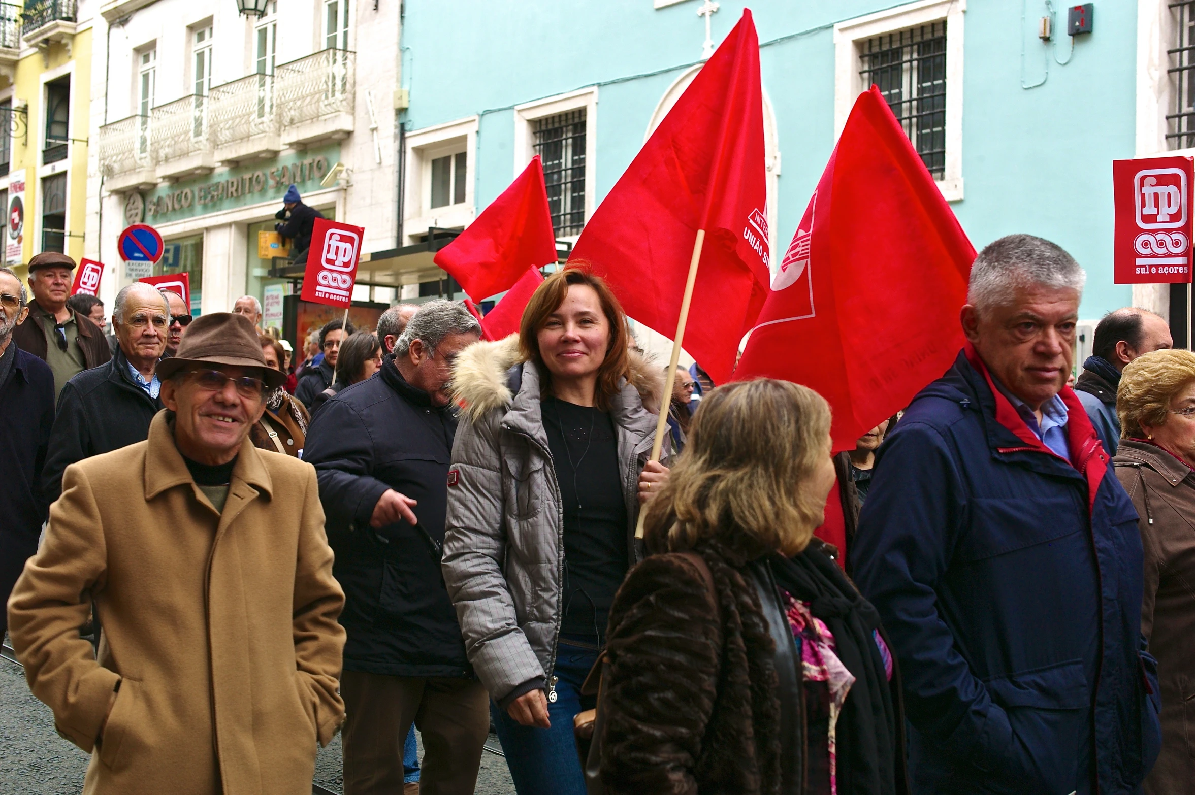 a large group of people standing next to each other holding red flags