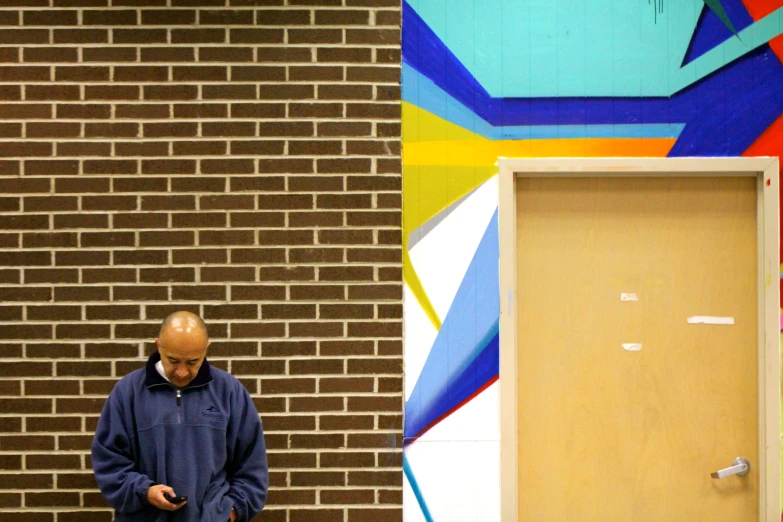 a man walks through a doorway by a graffiti wall