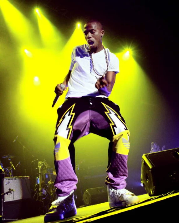 a black man with a purple pants on stage