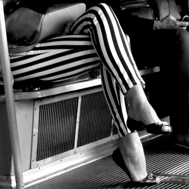 a woman in striped dress sitting on a train