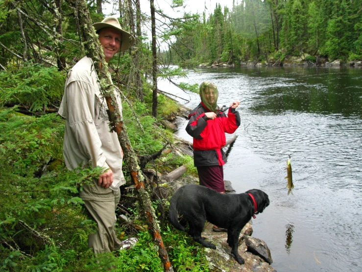 an elderly couple are standing by the stream