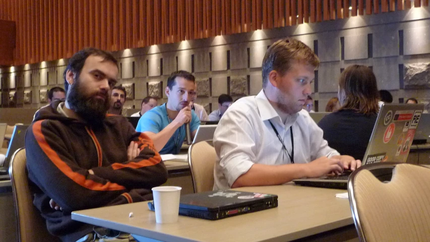 group of people using lap tops at tables in the liry