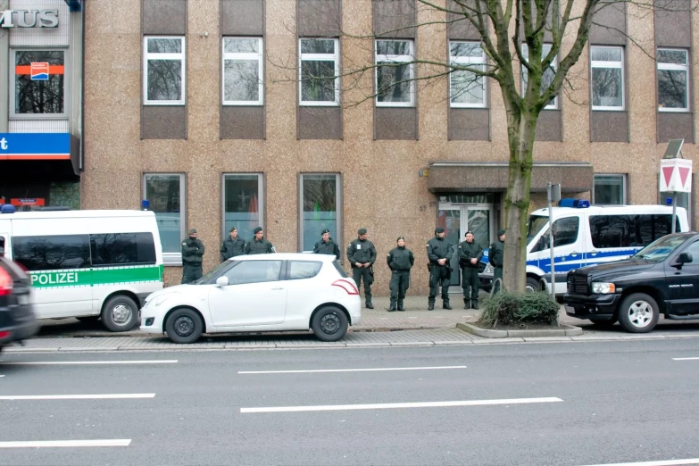 three police cars parked next to a large building