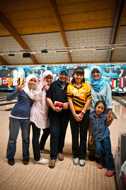 a family of seven standing in a bowling alley