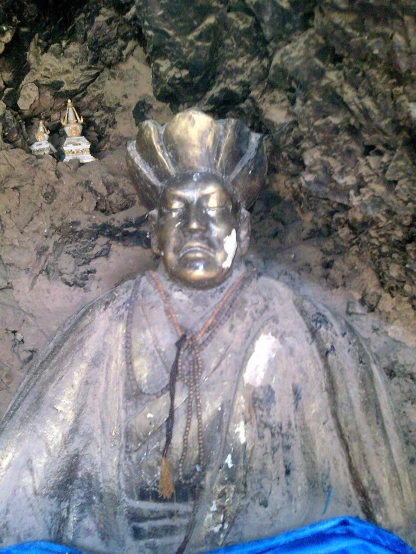 there is a statue sitting next to other buddhas