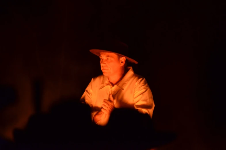 the man is wearing a hat in the dark