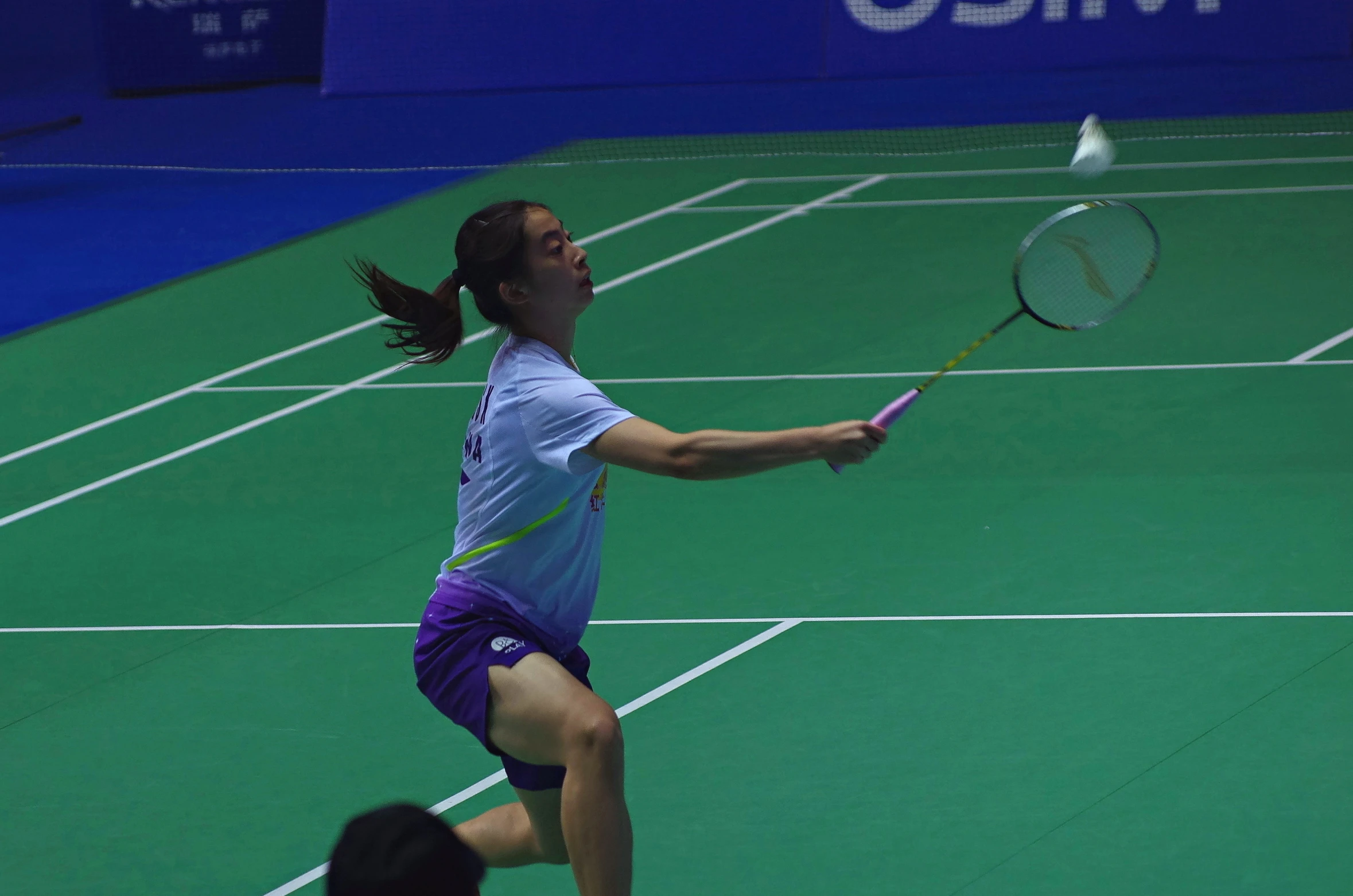 a girl is playing tennis on a green court