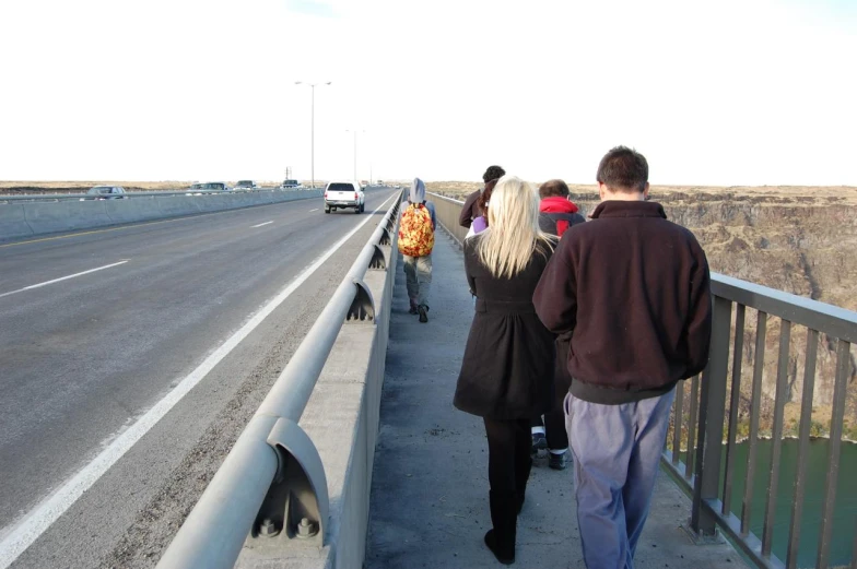 a group of people watching traffic go by on a highway