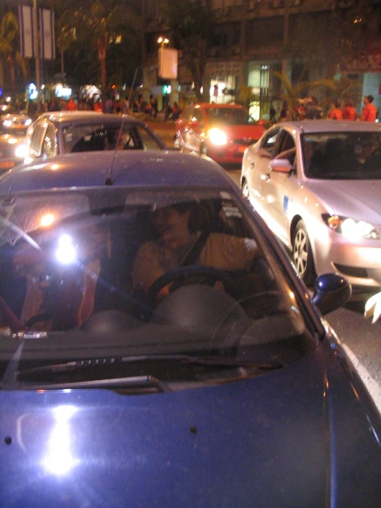 several cars driving down a street at night