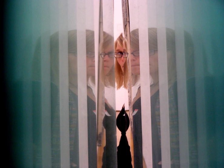 two women looking through curtains into the mirror