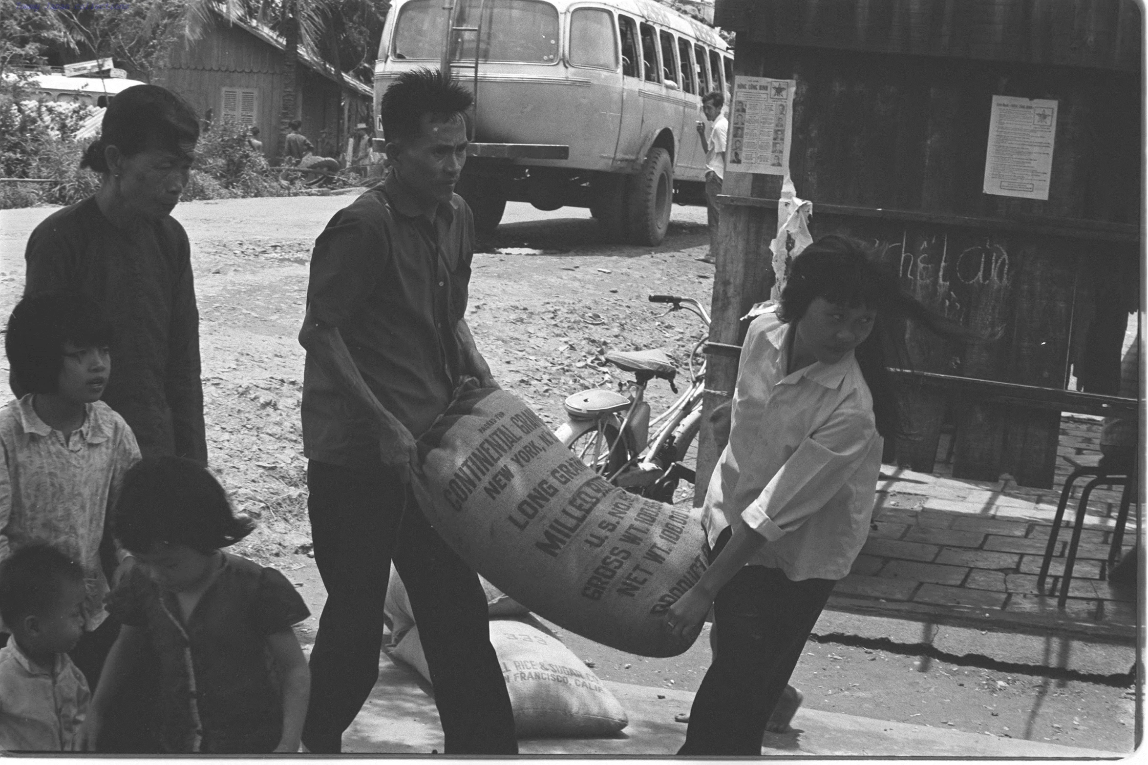 four people on a road carrying luggage