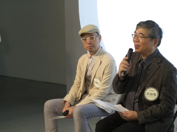 three people sitting together in chairs with microphones