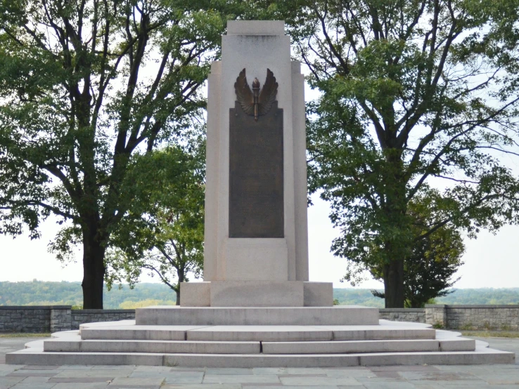 a memorial sitting next to a bunch of trees