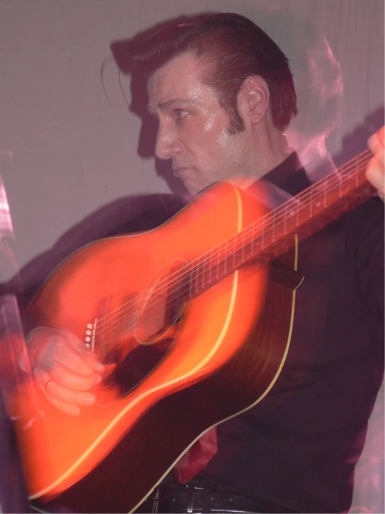 a man holding a guitar at the center of his body