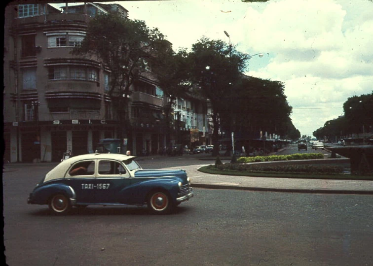 a old fashioned car travels through the city streets