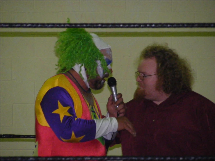a clown speaking to a man in a red shirt